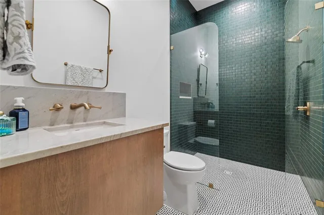 a bathroom with a sink a toilet and shower