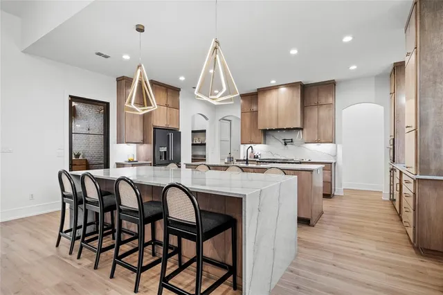 a kitchen with stainless steel appliances granite countertop a kitchen island a stove a table and chairs