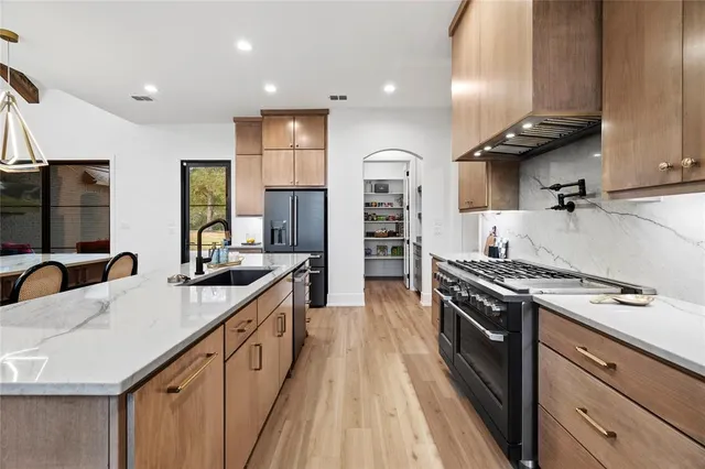 a kitchen with stainless steel appliances a sink stove and refrigerator