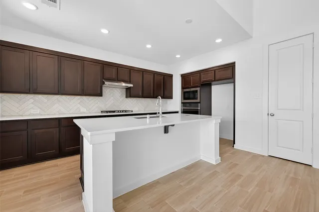 a kitchen with stainless steel appliances granite countertop a refrigerator sink and cabinets
