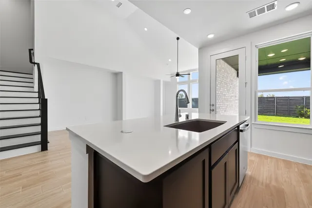 a kitchen with stainless steel appliances granite countertop a sink and a refrigerator