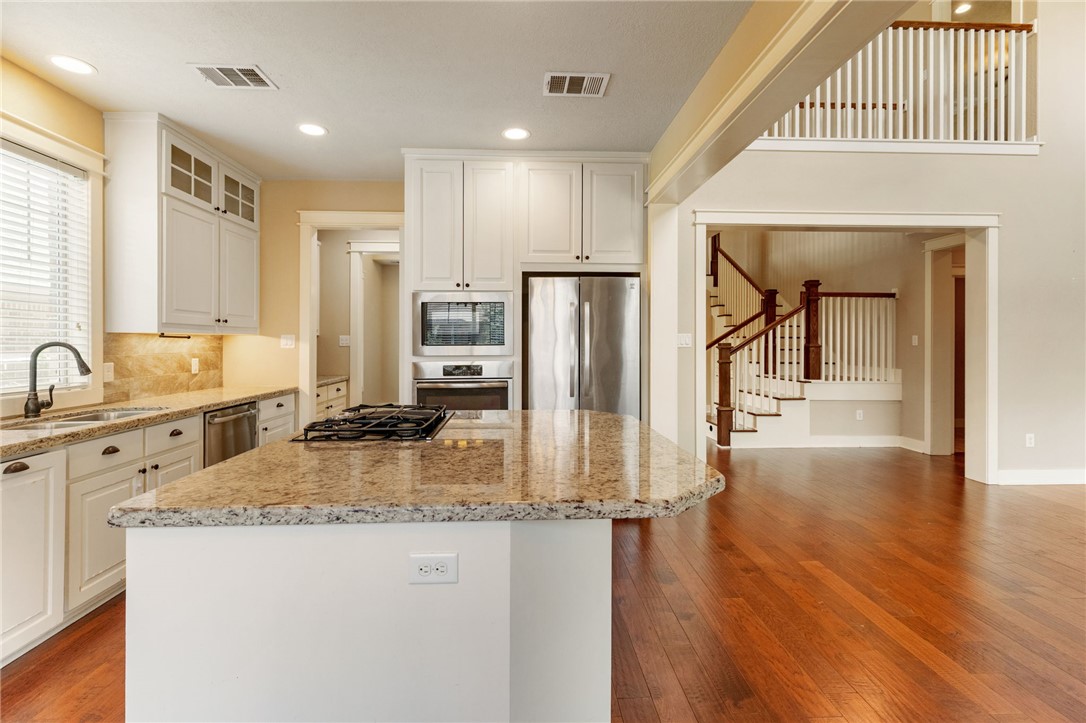 2136 Rockcliffe Loop College Station, TX 77845 - Photo 19 of 48 a kitchen with stainless steel appliances granite countertop a sink refrigerator and cabinets