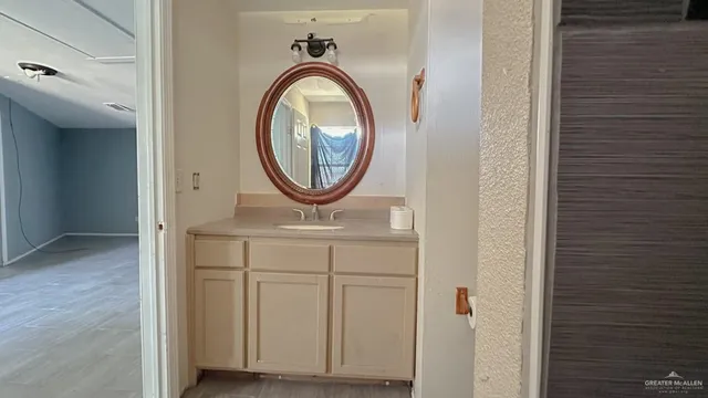 an empty room with wooden floor and a sink