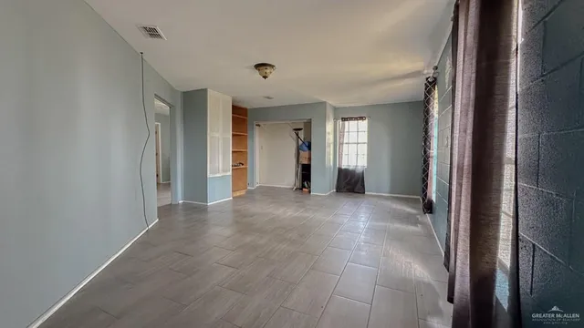 an empty room with closet and windows