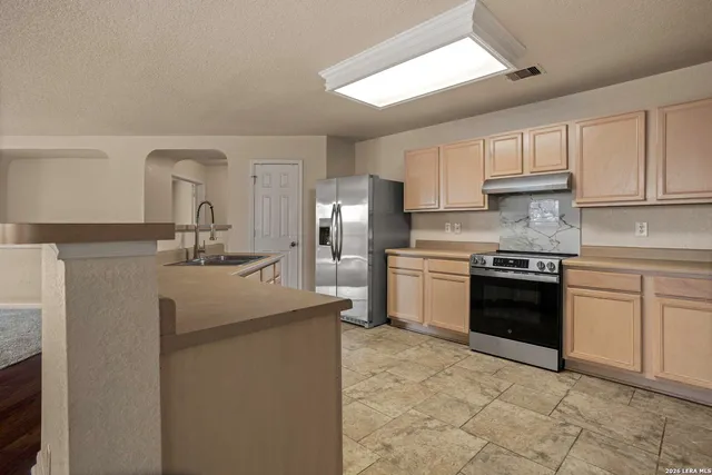a kitchen with a sink stove and cabinets