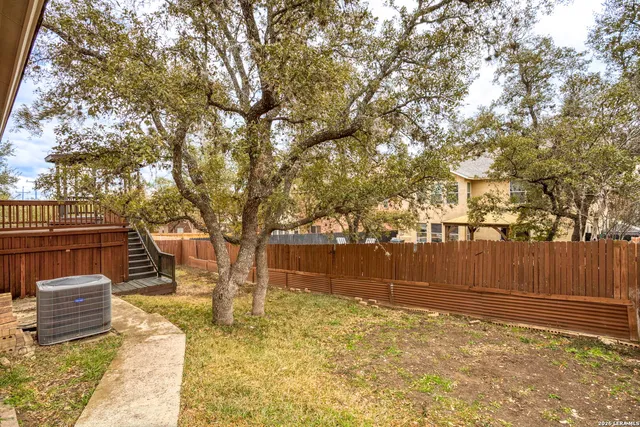 a view of a yard with wooden fence