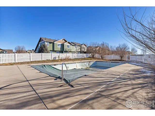 a view of a backyard with plants and wooden fence