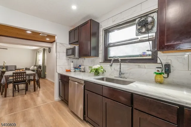 a kitchen with sink a window and chairs