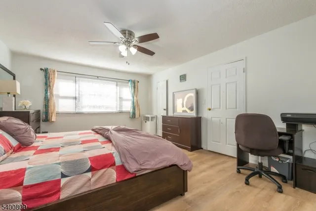 a bedroom with a bed a desk and chair with window