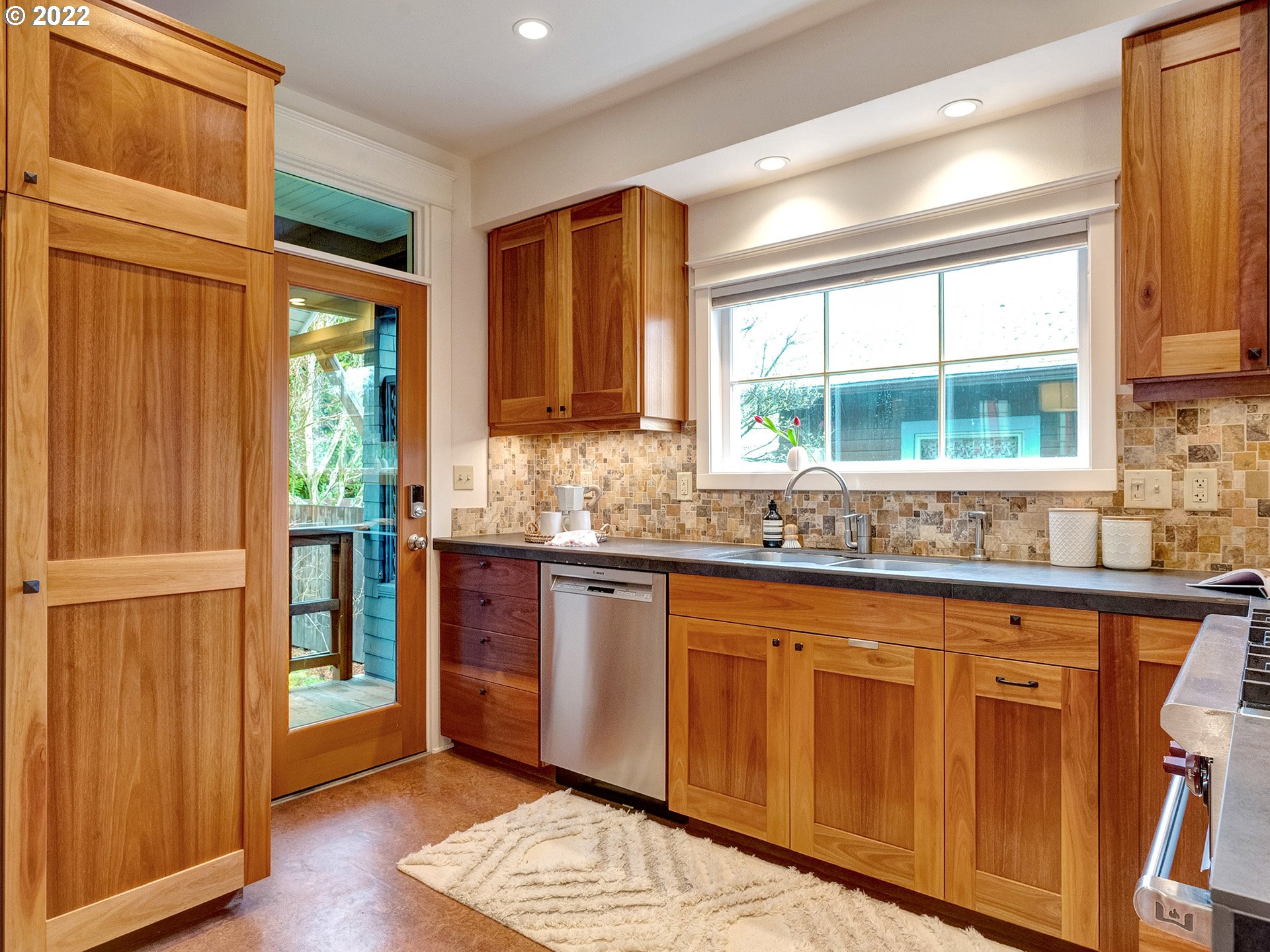 2307 Northeast Couch Street Portland, OR 97232 - Photo 14 of 32 a kitchen with granite countertop wooden cabinets a sink and a window