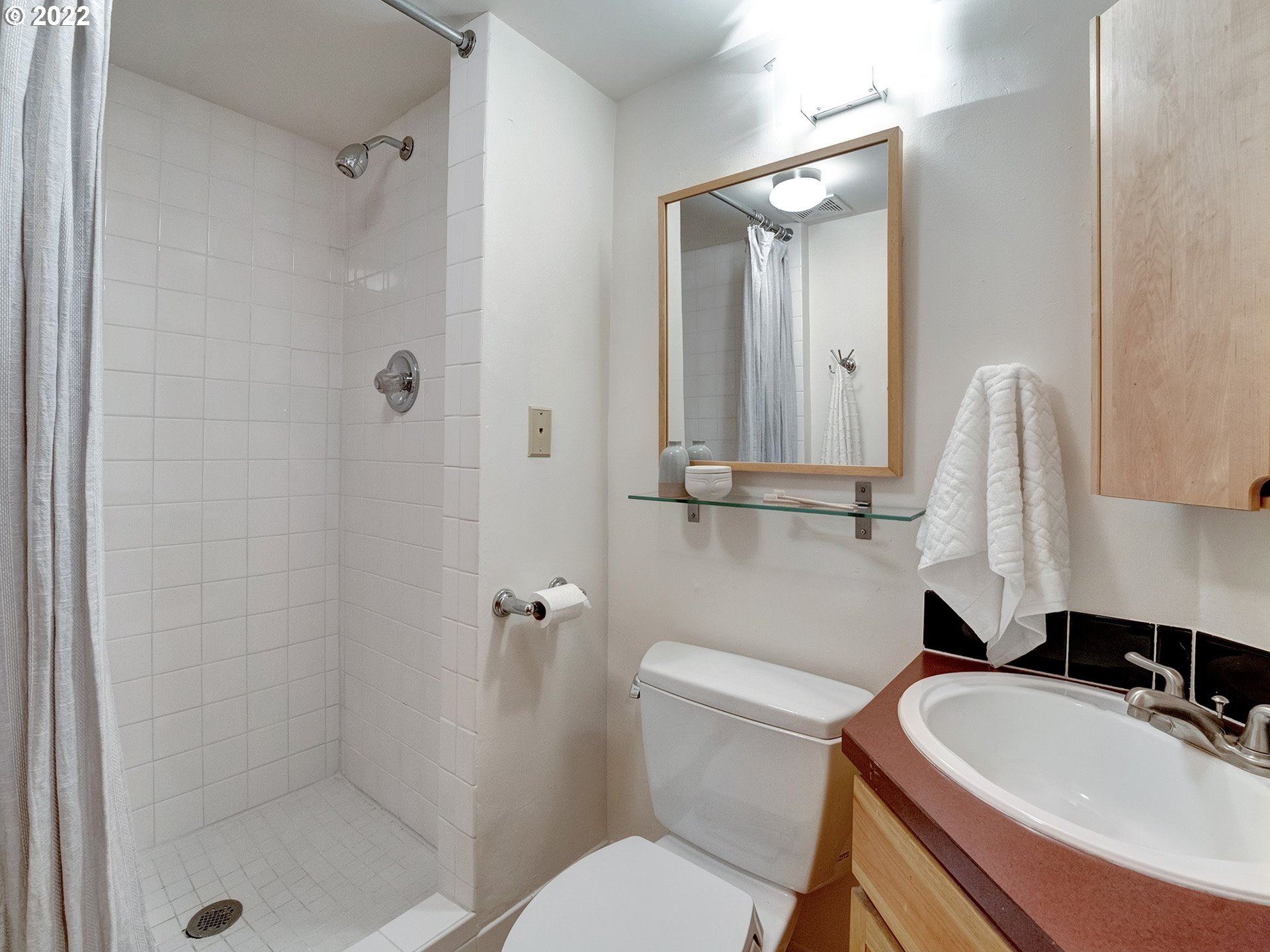 2307 Northeast Couch Street Portland, OR 97232 - Photo 28 of 32 a bathroom with a sink a toilet a mirror and shower