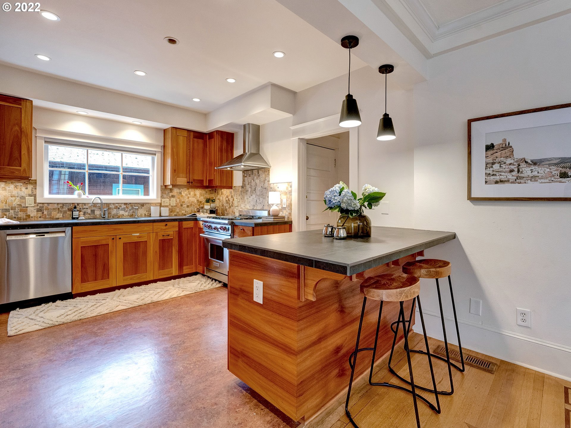 2307 Northeast Couch Street Portland, OR 97232 - Photo 10 of 32 a kitchen with stainless steel appliances granite countertop a sink a stove and a wooden floors