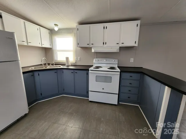 a kitchen with granite countertop a sink stove and cabinets