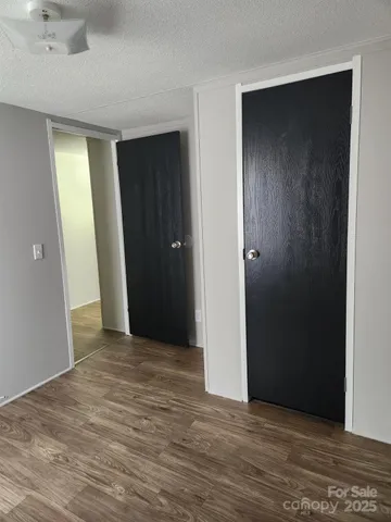 a view of an empty room with closet and a bathroom