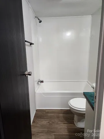 a bathroom with a toilet and a shower