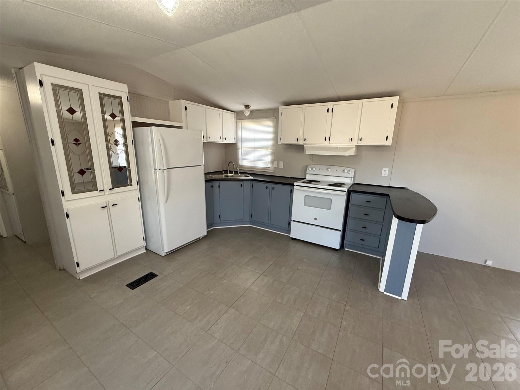 450 Ridgeland Drive Cleveland, NC 27013 - Photo 8 of 14 a kitchen with a refrigerator a stove and white cabinets