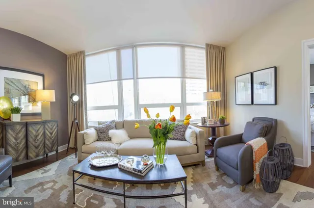 a living room with furniture couches and a large window