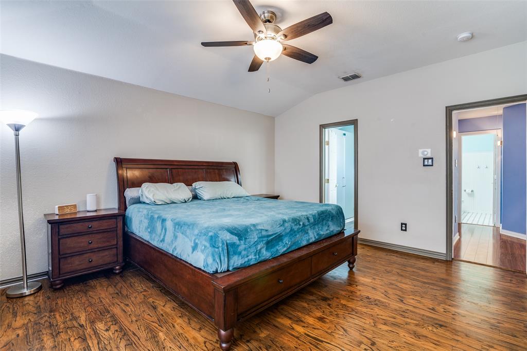 10702 Augusta Lane Rowlett, TX 75089 - Photo 15 of 25 a bedroom with a bed and a chandelier