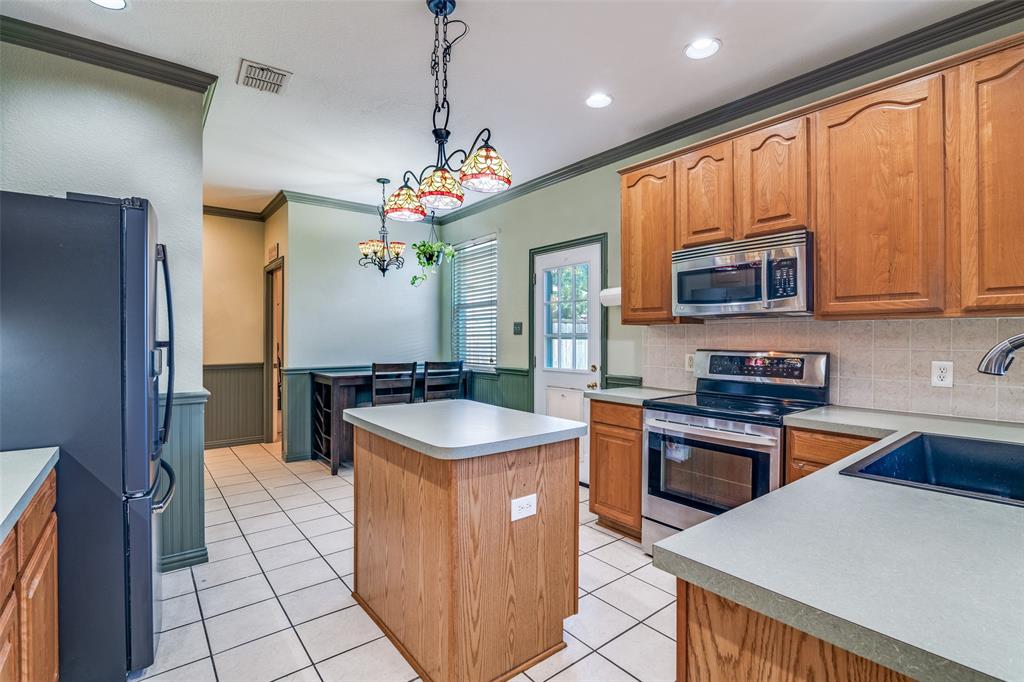 10702 Augusta Lane Rowlett, TX 75089 - Photo 8 of 25 a kitchen with stainless steel appliances granite countertop a sink stove and refrigerator