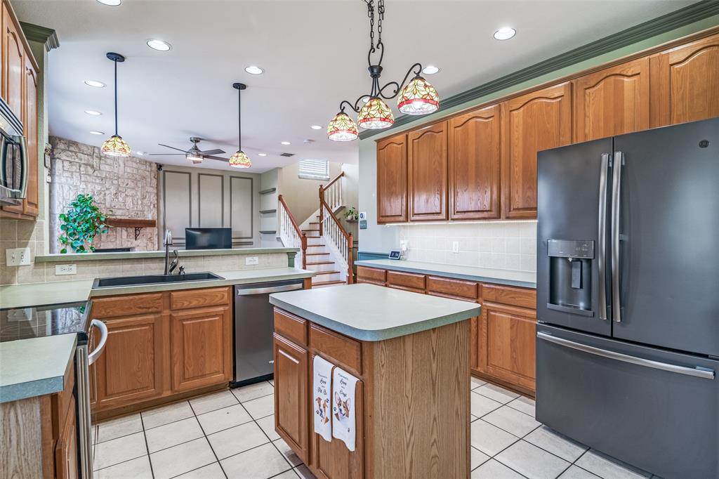 10702 Augusta Lane Rowlett, TX 75089 - Photo 9 of 25 a kitchen with stainless steel appliances granite countertop a sink a counter space and a window