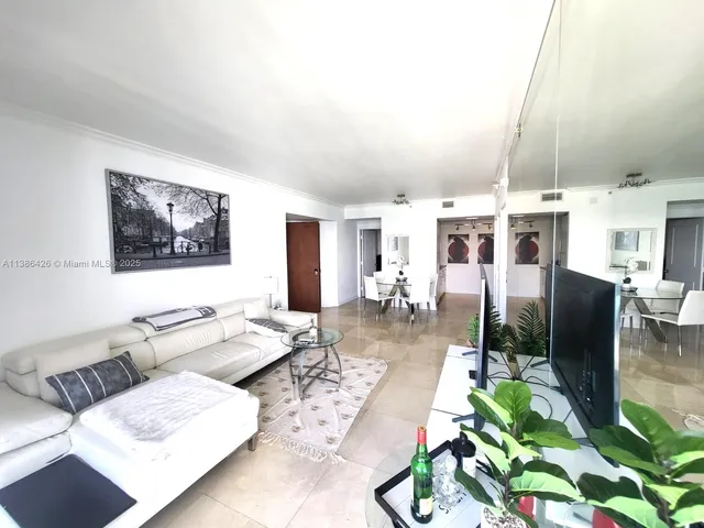 a living room with patio furniture and a flat screen tv