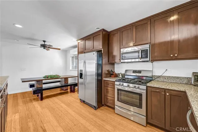 a kitchen with granite countertop wooden cabinets stainless steel appliances and a counter space