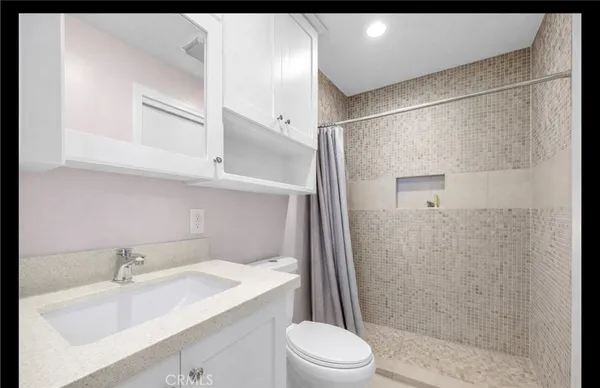 a bathroom with a sink toilet and shower