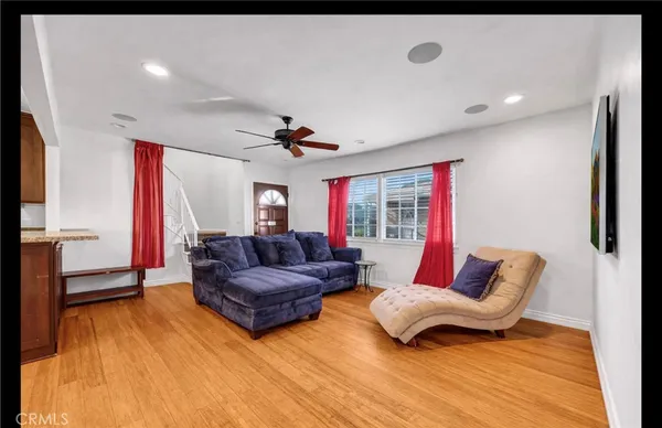 a living room with furniture and a wooden floor