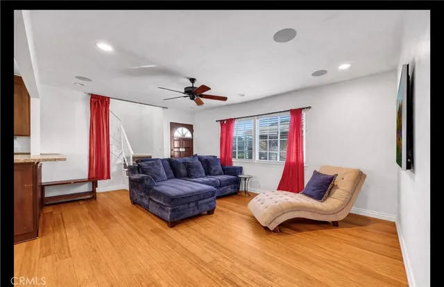 a living room with furniture and a wooden floor
