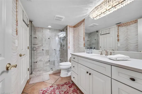 a spacious bathroom with a double vanity sink toilet mirror and shower