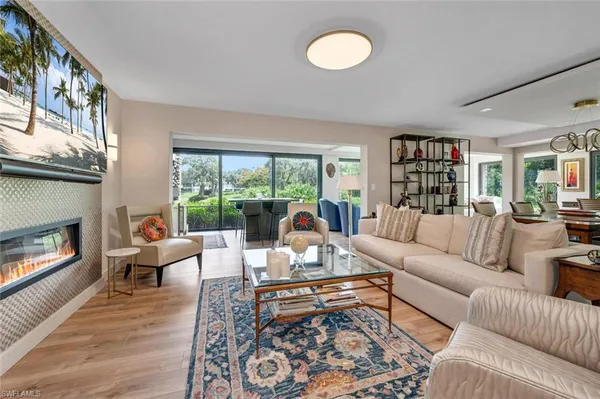 a living room with furniture fireplace and a large window