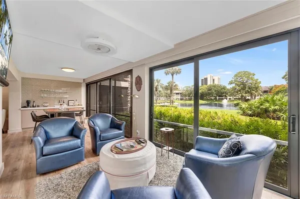 a living room with patio furniture and a potted plant