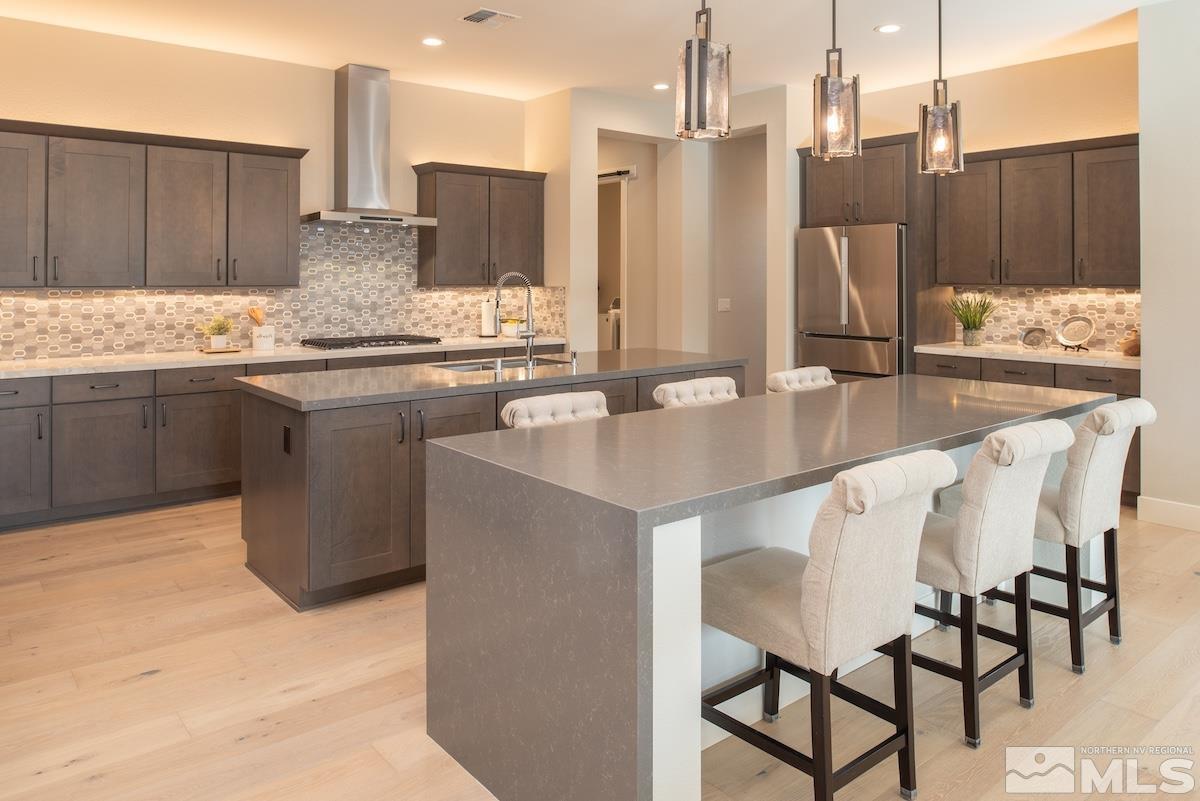 3012 Feathertop Drive Reno, NV 89521 - Photo 17 of 40 a kitchen with stainless steel appliances granite countertop a table chairs and a refrigerator