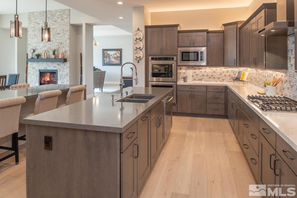 3012 Feathertop Drive Reno, NV 89521 - Photo 18 of 40 a kitchen with stainless steel appliances granite countertop a sink a stove and a refrigerator