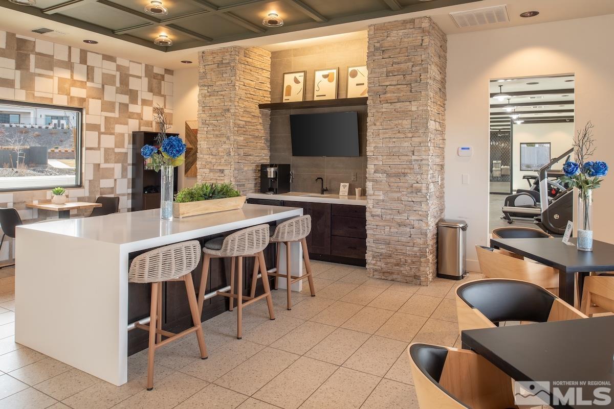 3012 Feathertop Drive Reno, NV 89521 - Photo 36 of 40 a kitchen with stainless steel appliances kitchen island granite countertop a table chairs in it and wooden floors