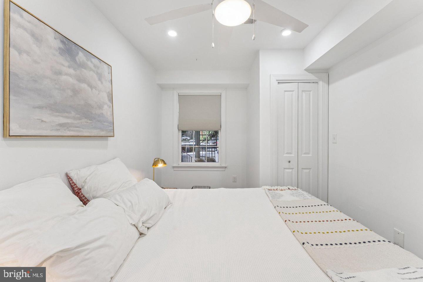718 Jackson Street Northeast, Unit 1 Washington, DC 20017 - Photo 12 of 22 a bedroom with a large bed and a painting on the wall
