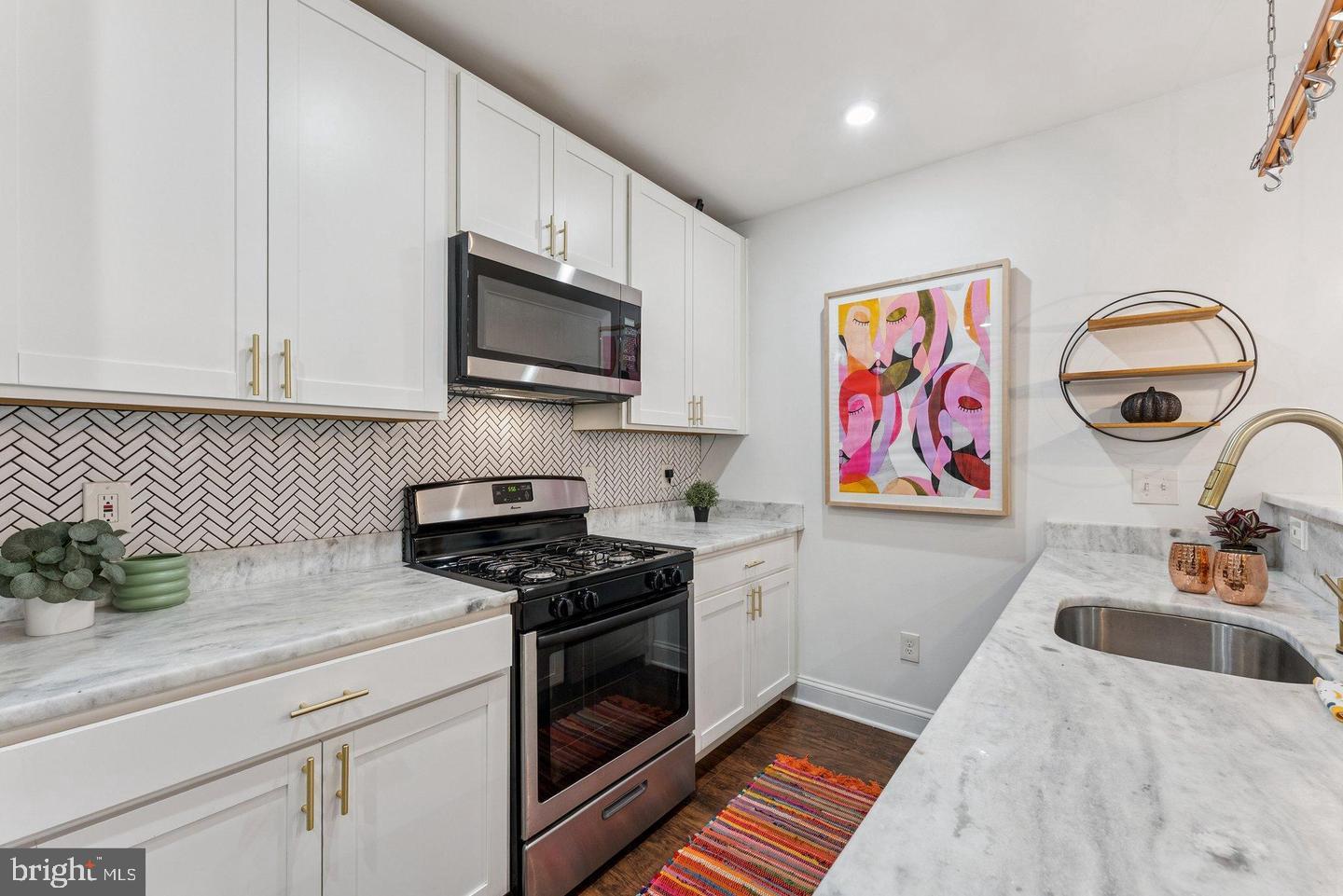 718 Jackson Street Northeast, Unit 1 Washington, DC 20017 - Photo 5 of 22 a kitchen with stainless steel appliances granite countertop a sink stove top oven and cabinets