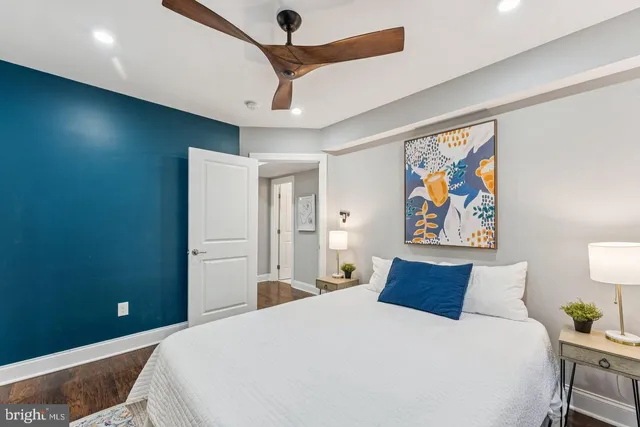 a bedroom with a bed and a painting on the wall