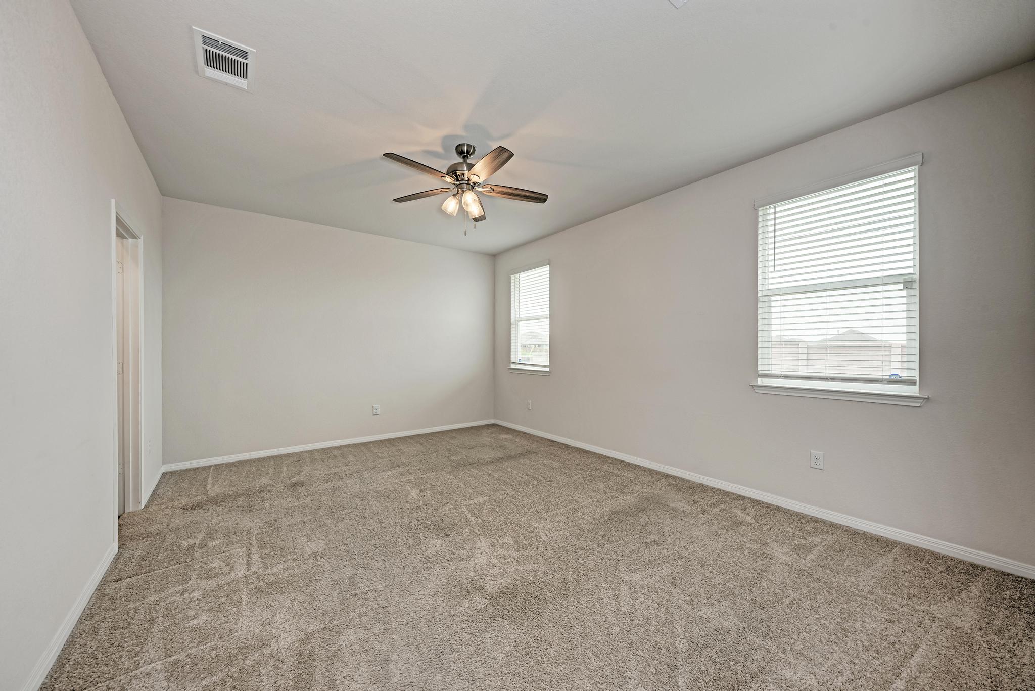 208 Abby Road Georgetown, TX 78626 - Photo 24 of 40 an empty room with windows and ceiling fan