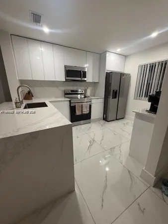 a kitchen with stainless steel appliances a refrigerator stove microwave and sink