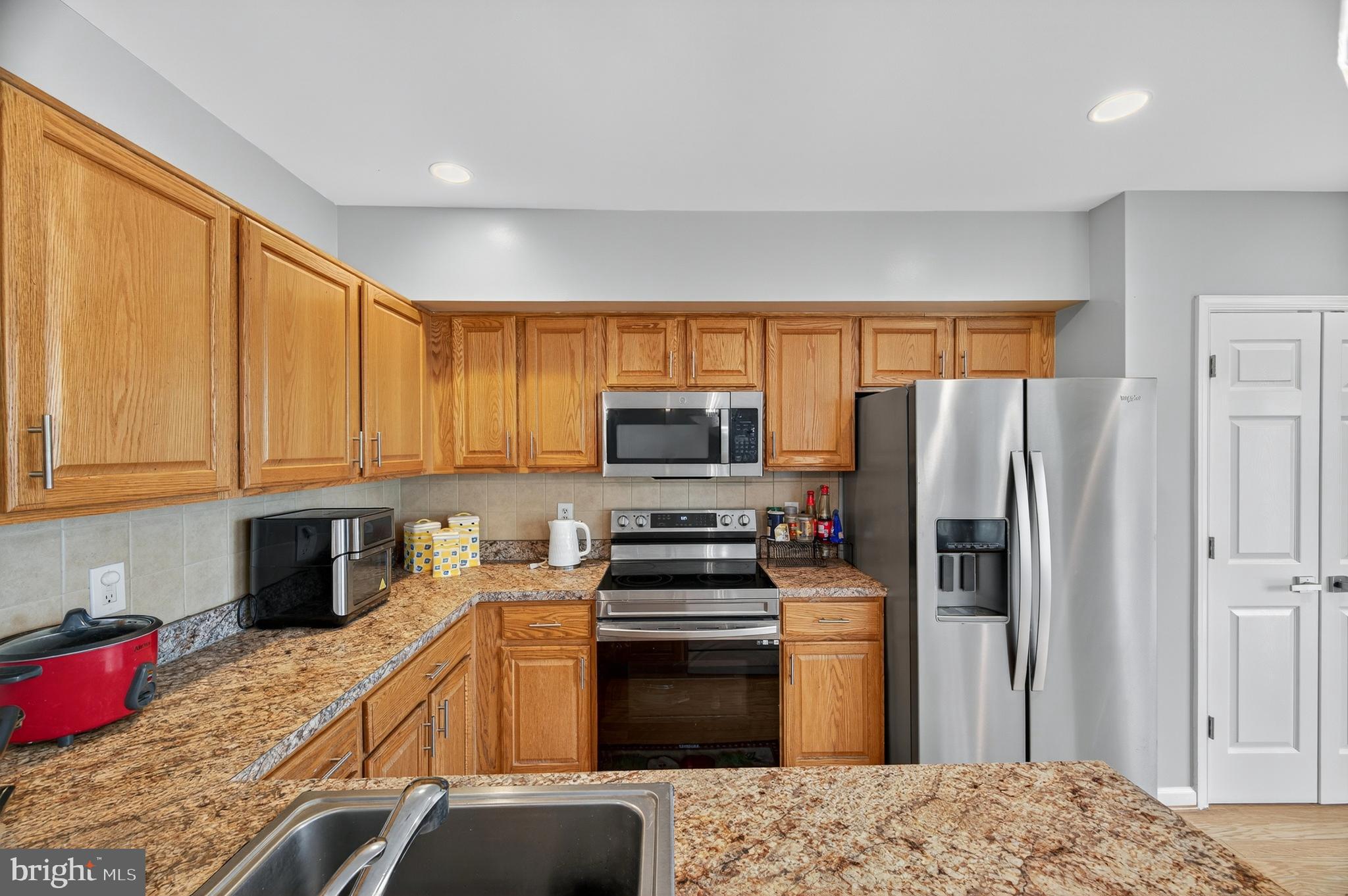 2046 University Boulevard West, Unit 12 Silver Spring, MD 20902 - Photo 3 of 64 a kitchen with granite countertop a refrigerator stove and oven
