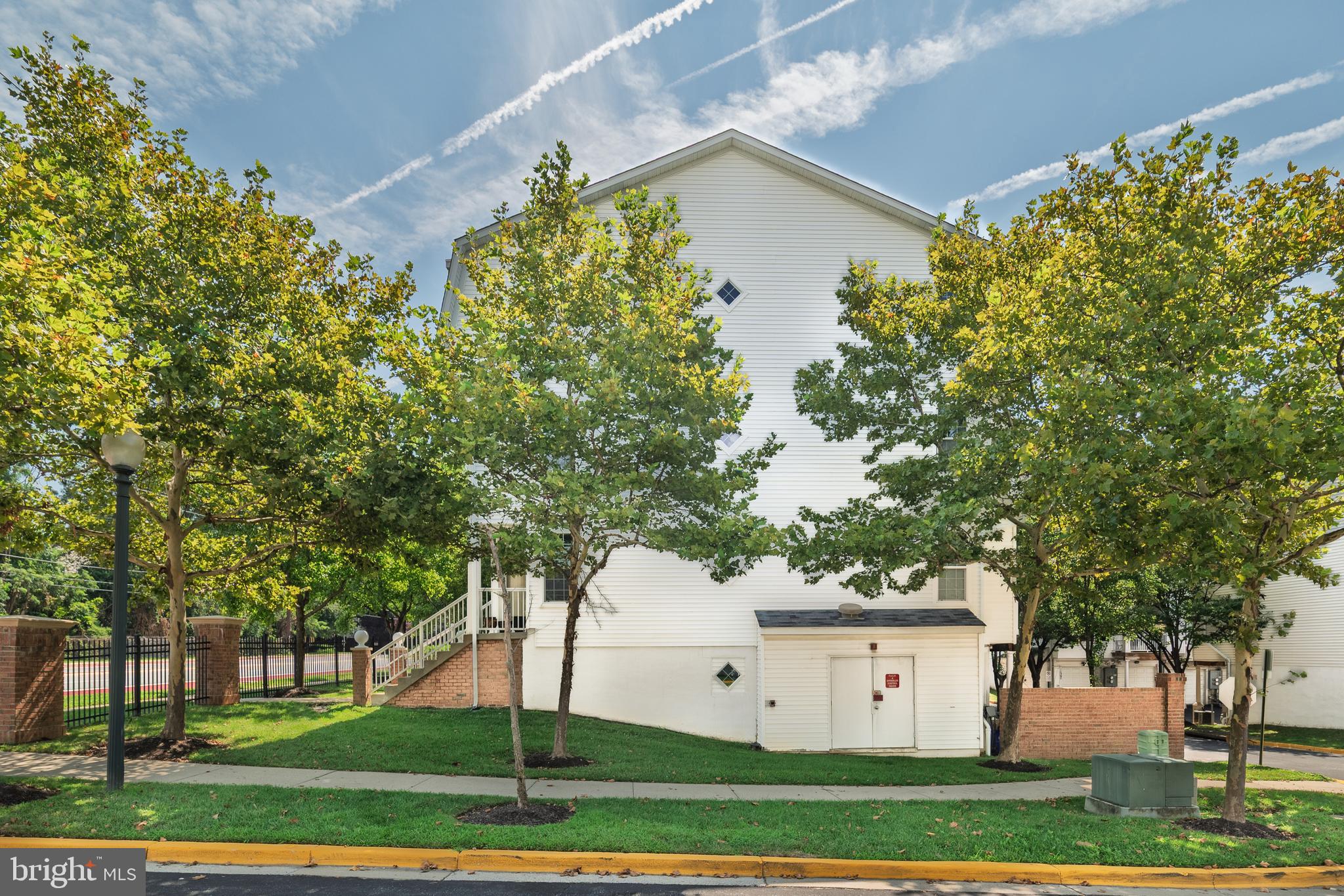 2046 University Boulevard West, Unit 12 Silver Spring, MD 20902 - Photo 41 of 64 a view of a white house with a yard and plants