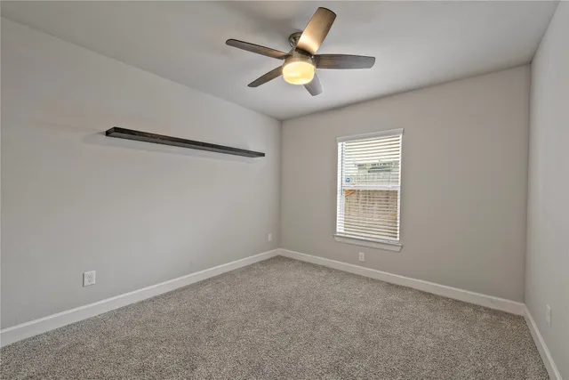 an empty room with closet and fan
