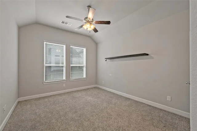 an empty room with windows and fan