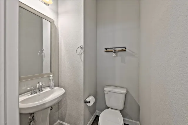 a bathroom with a toilet a sink and mirror