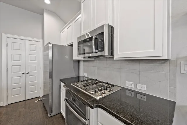 a kitchen with stainless steel appliances granite countertop a stove and a refrigerator