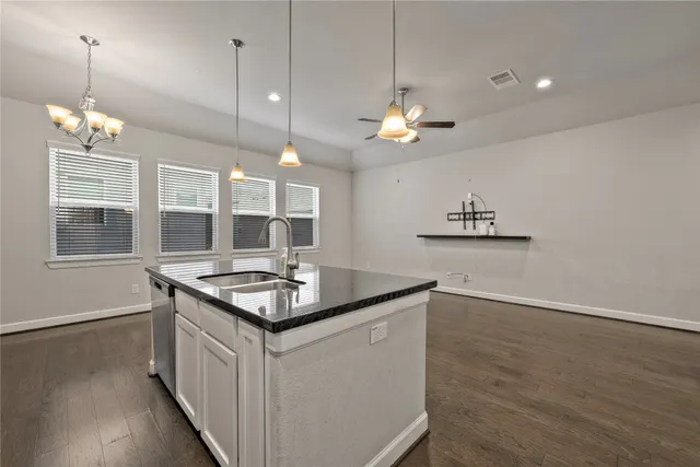 a kitchen counter space wooden floor and a chandelier