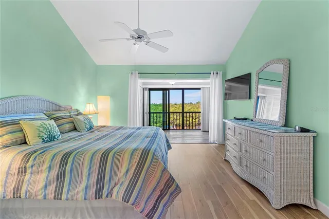 a bedroom with a bed and a flat tv screen on the dresser