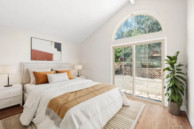 an empty room with wooden floor cabinet and windows