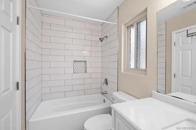 a bedroom with a large bed and windows